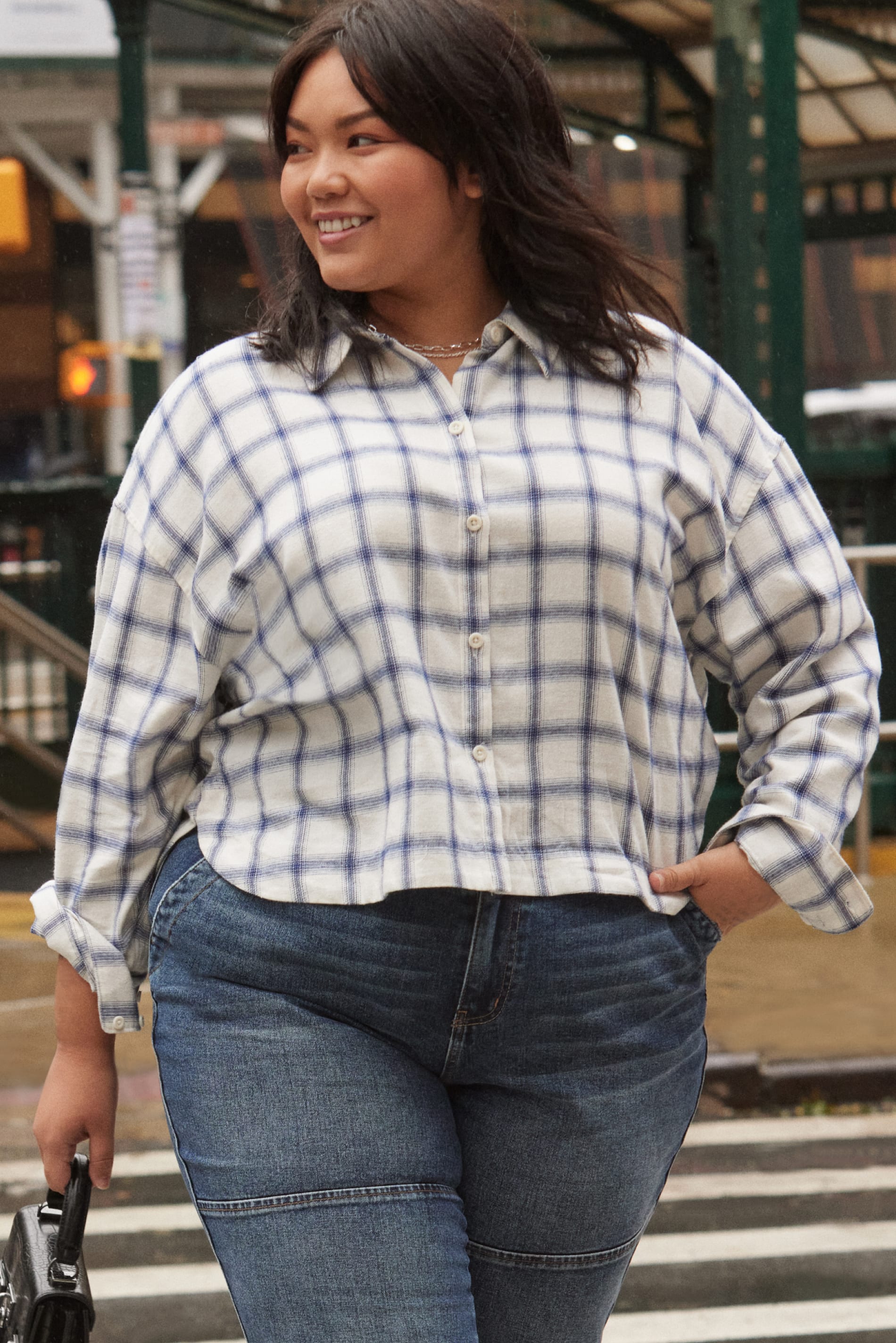 Plus model wearing Stitch Fix women’s clothing including trending denim and a button-down shirt.